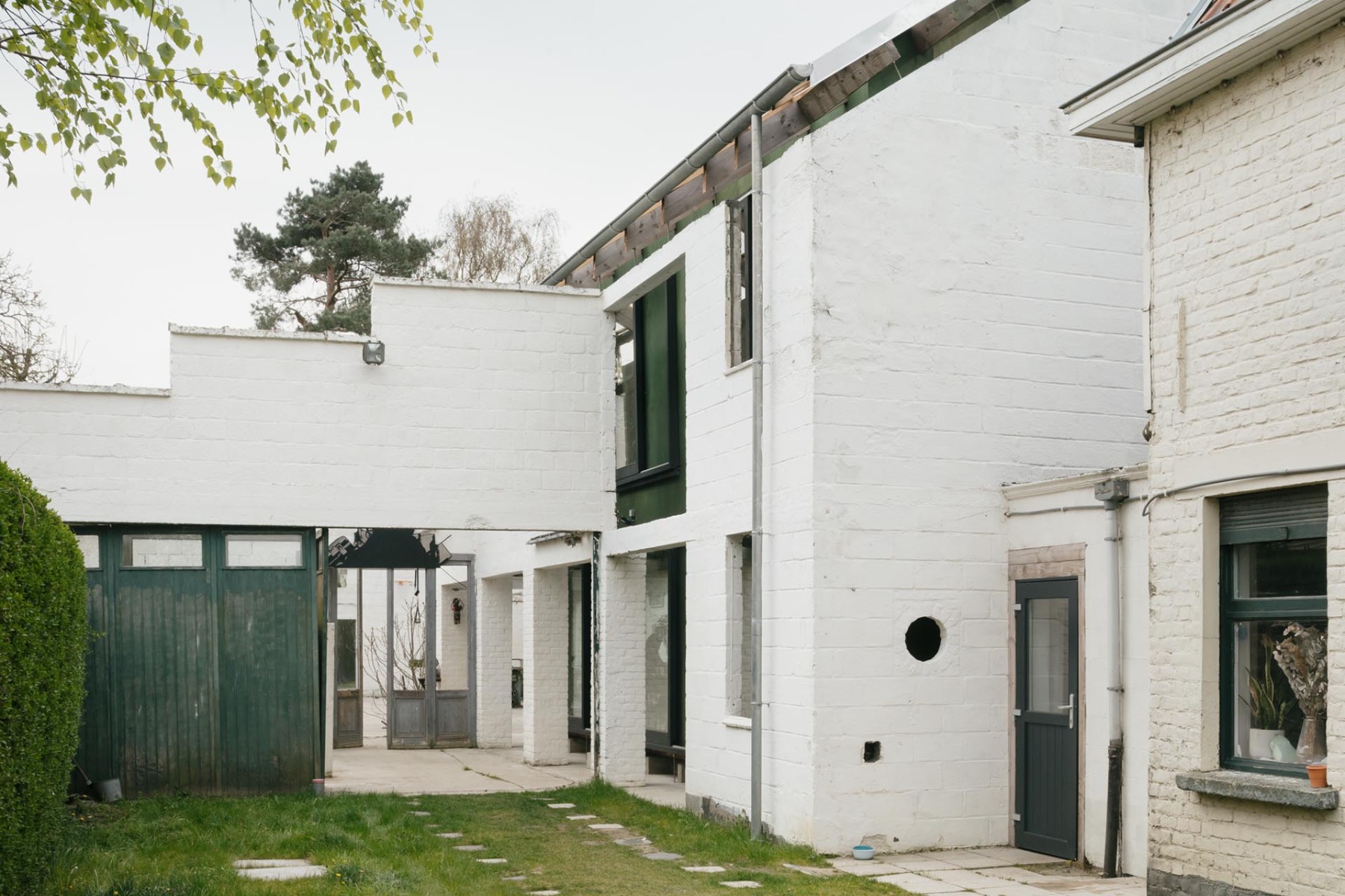 Innerhalb der Außenmauern der alten Schreinerei liegt das neue Holzhaus. © Stjin Bollaert