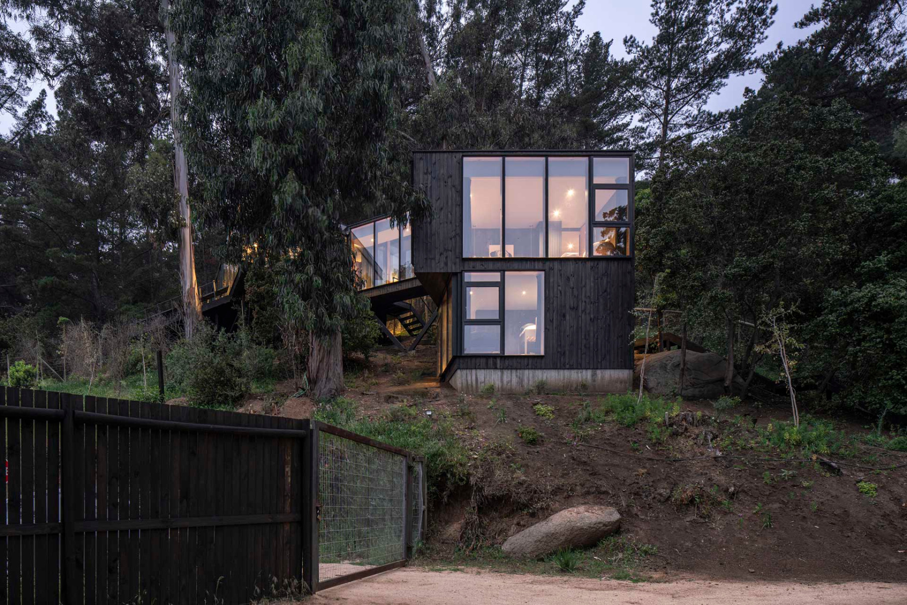 The new building is located further down the slope and is connected to the existing building by a main road. © Nicolás Saieh