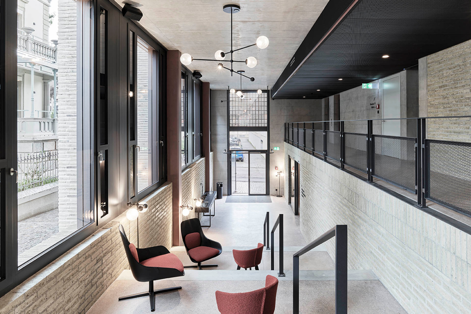 The internal walls are constructed of unfired clay bricks between red-pigmented concrete columns. © Kuster Frey