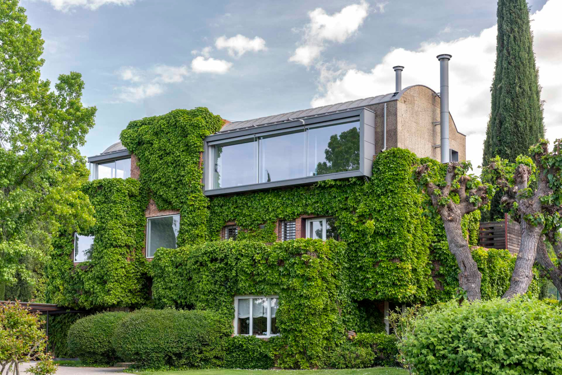 Das Wohnhaus wird von einem neuen Geschoss mit Tonnendach gekrönt. © Luis Asín