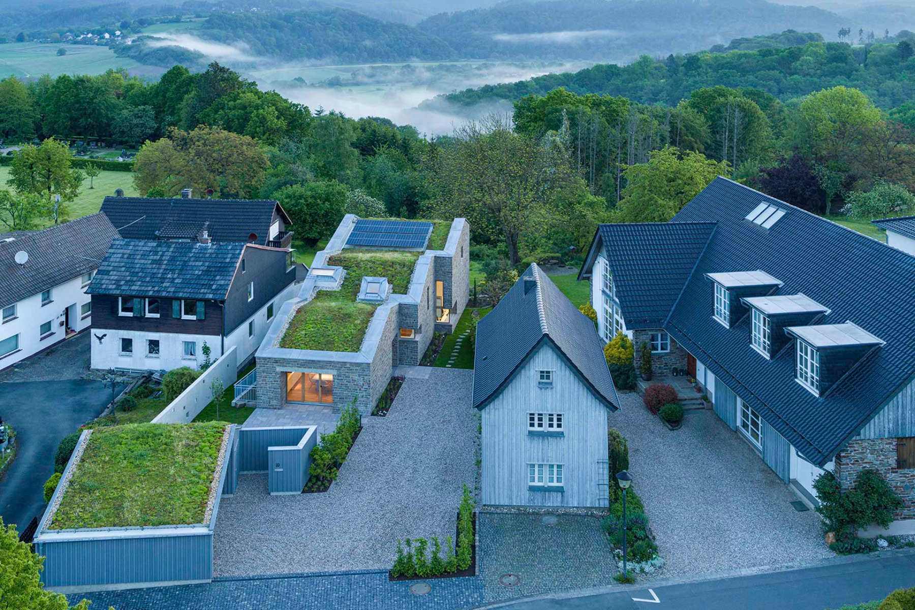 Das Atelierhaus für den Architekturfotografen HG Esch entwickelt sich in drei Abschnitten hangabwärts, wobei das größte und höchste Volumen den Schlusspunkt bildet. © HGEsch Photography