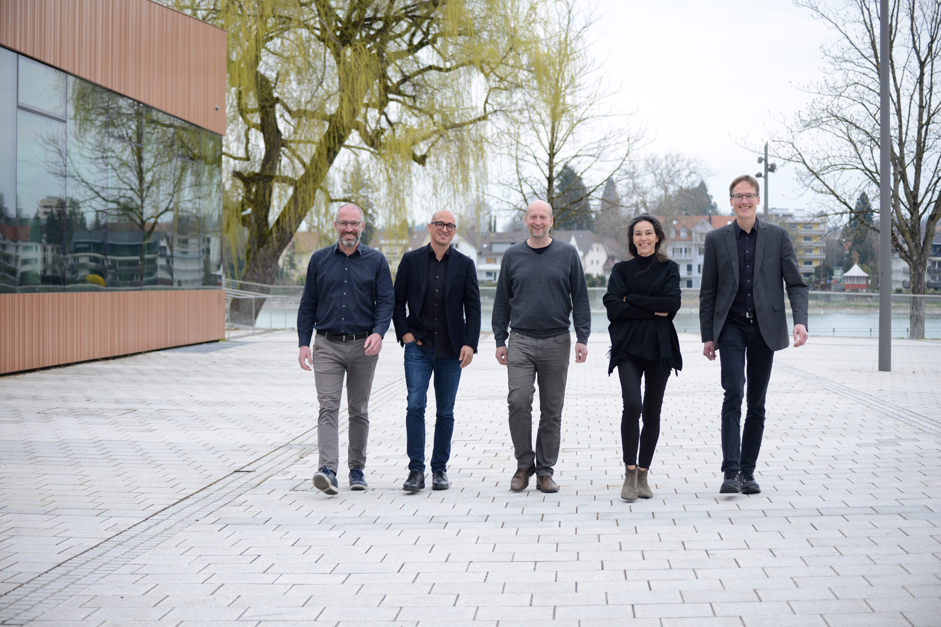 Die vier Männer und eine Frau der VELUX Jury laufen einen gepflasterten Weg entlang.